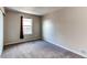 This cozy bedroom features plush carpeting, a window with natural light, and neutral paint colors at 55490 E 27Th Pl, Strasburg, CO 80136