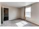 This bedroom features plush carpeting, a window with natural light, and neutral paint colors at 55490 E 27Th Pl, Strasburg, CO 80136