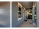 Close-up of the covered porch, showing the front door and exterior of the blue home at 55490 E 27Th Pl, Strasburg, CO 80136