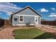 A detached garage with light gray horizontal siding, white trim, artificial turf, and wood perimeter fencing at 55490 E 27Th Pl, Strasburg, CO 80136