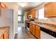 Well-lit kitchen features tile floors, wooden cabinets, and modern appliances, with sight-lines into adjacent living area at 55490 E 27Th Pl, Strasburg, CO 80136