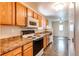 Functional kitchen featuring wood cabinets, white appliances, and tile floors at 55490 E 27Th Pl, Strasburg, CO 80136