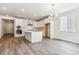 An open-concept kitchen with hardwood flooring, white cabinets, and stainless steel appliances at 39161 Anthony St, Elizabeth, CO 80107