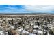 An aerial view of the home and its community, landscaped yards, and snowy scenery at 5121 W Plymouth Dr, Littleton, CO 80128