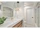 Bathroom featuring a modern vanity with a round mirror and glass shower with gold hardware at 5121 W Plymouth Dr, Littleton, CO 80128