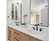 Bathroom featuring double sinks with matte black hardware, a stone countertop, and a modern vanity at 5121 W Plymouth Dr, Littleton, CO 80128