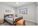 A cozy bedroom featuring a wooden bed frame, warm colors, and a bright sunny window at 5121 W Plymouth Dr, Littleton, CO 80128