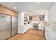 Bright kitchen with stainless steel appliances, white cabinets, and wood floors at 5121 W Plymouth Dr, Littleton, CO 80128