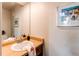 Bathroom sink with wood countertop, mirror and decorative artwork at 4621 S Fraser Cir # A, Aurora, CO 80015