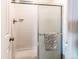 Shower with sliding glass door featuring chrome fixtures and tile walls at 4621 S Fraser Cir # A, Aurora, CO 80015