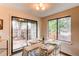 Bright dining area with a glass table, modern chairs, and sliding glass doors leading to the outside at 4621 S Fraser Cir # A, Aurora, CO 80015