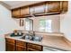 Open-concept kitchen featuring wooden cabinets with a pass-through window for serving and entertaining at 4621 S Fraser Cir # A, Aurora, CO 80015