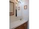 Bathroom featuring a white sink and laminate countertop over wood cabinets, and a large mirror at 11299 E 159Th Pl, Brighton, CO 80602