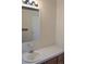 Bathroom featuring a white sink and laminate countertop over wood cabinets, and a large mirror at 11299 E 159Th Pl, Brighton, CO 80602