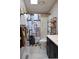 Bathroom with updated vanity, shower with patterned curtain, and storage shelves with rolled towels at 11299 E 159Th Pl, Brighton, CO 80602