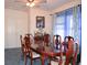 Classic dining room with wooden table, seating for six, carpeted floors and window with sheer blue curtains at 11299 E 159Th Pl, Brighton, CO 80602