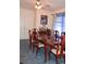 Classic dining room with wooden table, seating for six, carpeted floors and window with sheer blue curtains at 11299 E 159Th Pl, Brighton, CO 80602