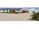 Exterior view of white home with a detached garage and gravel driveway at 11299 E 159Th Pl, Brighton, CO 80602