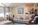 Cozy living room with plush seating, a modern painting, and vaulted ceilings at 11299 E 159Th Pl, Brighton, CO 80602