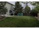 Lush backyard with manicured lawn, mature trees, and a barbecue grill for outdoor enjoyment at 11538 Hudson St, Thornton, CO 80233
