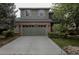 Two-story home boasts an attached garage, brick accents, a driveway, and mature landscaping at 11538 Hudson St, Thornton, CO 80233