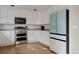 Chic kitchen with white cabinets, stainless steel appliances, and modern refrigerator at 11538 Hudson St, Thornton, CO 80233