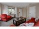 Cozy living room with large windows, carpet, neutral walls, and red seating at 11538 Hudson St, Thornton, CO 80233