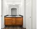 Bathroom with a wooden cabinet, double sink, a vanity mirror, and a white door at 2691 E 132Nd Ave, Thornton, CO 80241