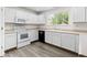 Bright and functional kitchen featuring white cabinets, modern appliances, and wood flooring at 2691 E 132Nd Ave, Thornton, CO 80241