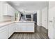 Open-concept living space with wood floors, white cabinets, and sliding glass doors to the outside at 2691 E 132Nd Ave, Thornton, CO 80241