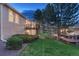 Backyard of home with lawn, trees and view of the home's deck on the back at 7454 Snow Lily Pl, Castle Pines, CO 80108