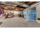 Unfinished basement area with exposed ceiling and sliding glass doors to the outside at 7454 Snow Lily Pl, Castle Pines, CO 80108