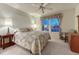 Carpeted bedroom with queen bed, side table with lamp, ceiling fan, and exterior window with curtains at 7454 Snow Lily Pl, Castle Pines, CO 80108