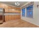 Bright dining area showcasing wooden cabinets, stainless steel refrigerator, and sunny windows at 7454 Snow Lily Pl, Castle Pines, CO 80108
