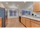 Open kitchen with stainless appliances, light wood cabinets, and a spacious dining area at 7454 Snow Lily Pl, Castle Pines, CO 80108