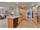Open concept kitchen with light wood cabinets, tile countertops, and adjacent living space at 7454 Snow Lily Pl, Castle Pines, CO 80108