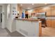 Charming kitchen with light wood cabinets, stainless steel appliances, and a cozy breakfast bar at 7454 Snow Lily Pl, Castle Pines, CO 80108