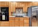 Well-lit kitchen features wood cabinetry, stainless steel appliances, and tile countertops at 7454 Snow Lily Pl, Castle Pines, CO 80108