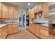 Bright kitchen showcases wood cabinets, tile backsplash, stainless appliances and ample counter space at 7454 Snow Lily Pl, Castle Pines, CO 80108
