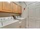 Bright laundry room with full-size washer and dryer units and storage space at 7454 Snow Lily Pl, Castle Pines, CO 80108