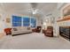 Bright living room with large windows, comfortable seating, and a fireplace at 7454 Snow Lily Pl, Castle Pines, CO 80108