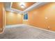 Finished basement with neutral carpet, bright window and orange accent walls at 2319 Decatur St, Denver, CO 80211