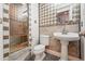Elegant bathroom featuring a tiled shower, pedestal sink, and stylish fixtures at 2319 Decatur St, Denver, CO 80211