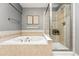 Bathroom featuring a soaking tub, a glass-enclosed shower and tile surround at 2319 Decatur St, Denver, CO 80211