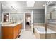 Primary bathroom featuring double sinks, soaking tub, and glass enclosed shower with tile surround at 2319 Decatur St, Denver, CO 80211