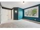 Bedroom featuring bright window, blue accent wall and two white doors at 2319 Decatur St, Denver, CO 80211