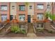 Brick townhome with steps leading to front door and manicured landscaping at 2319 Decatur St, Denver, CO 80211