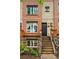 Brick townhome with steps leading to front door and manicured landscaping at 2319 Decatur St, Denver, CO 80211