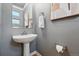 Updated half bathroom with pedestal sink, modern fixtures, and light gray walls at 2319 Decatur St, Denver, CO 80211