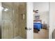 Bathroom featuring a tiled shower with glass door, adjacent to open bedroom view at 17623 Cornish Pl, Parker, CO 80134